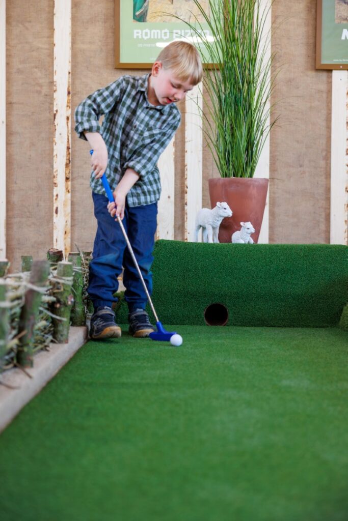 Dreng spiller minigolf