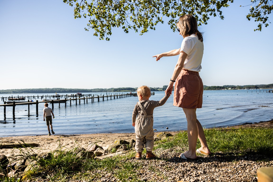 Mor og barn kigger ud over Genner Bugt