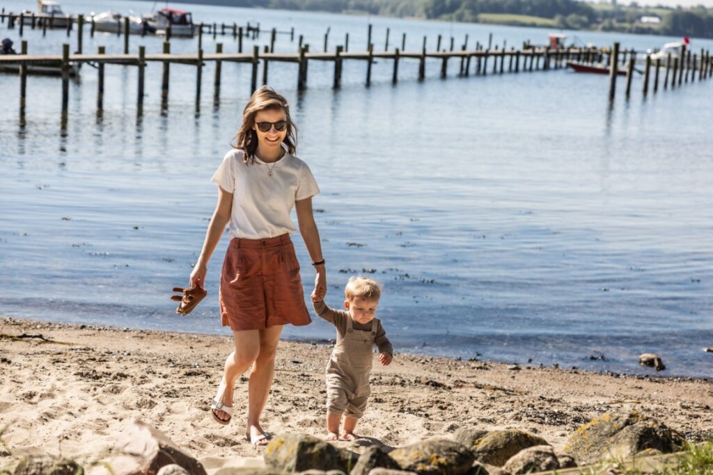 Mor og barn på strande ved Genner Bugt