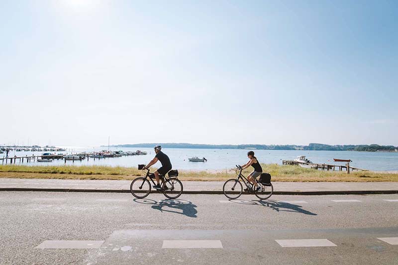 Par på cykeltur langs vandet