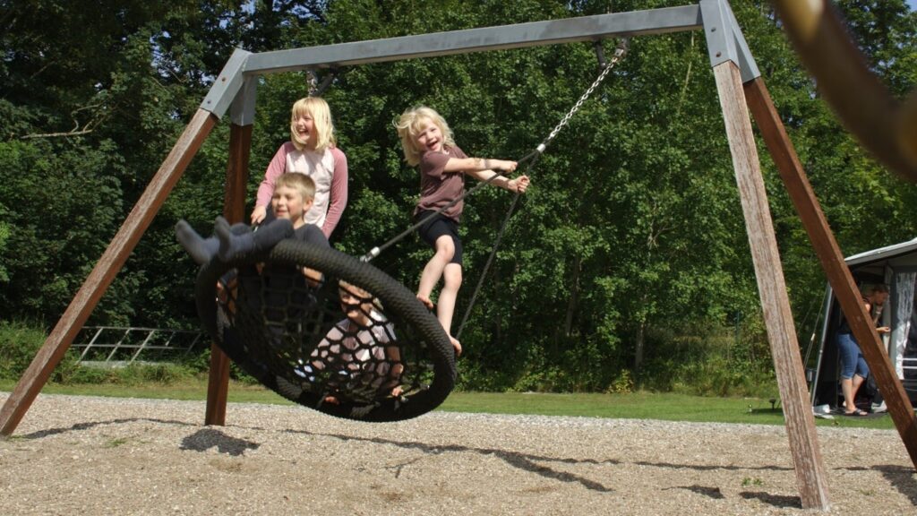 Legende børn der gynger på campingplads