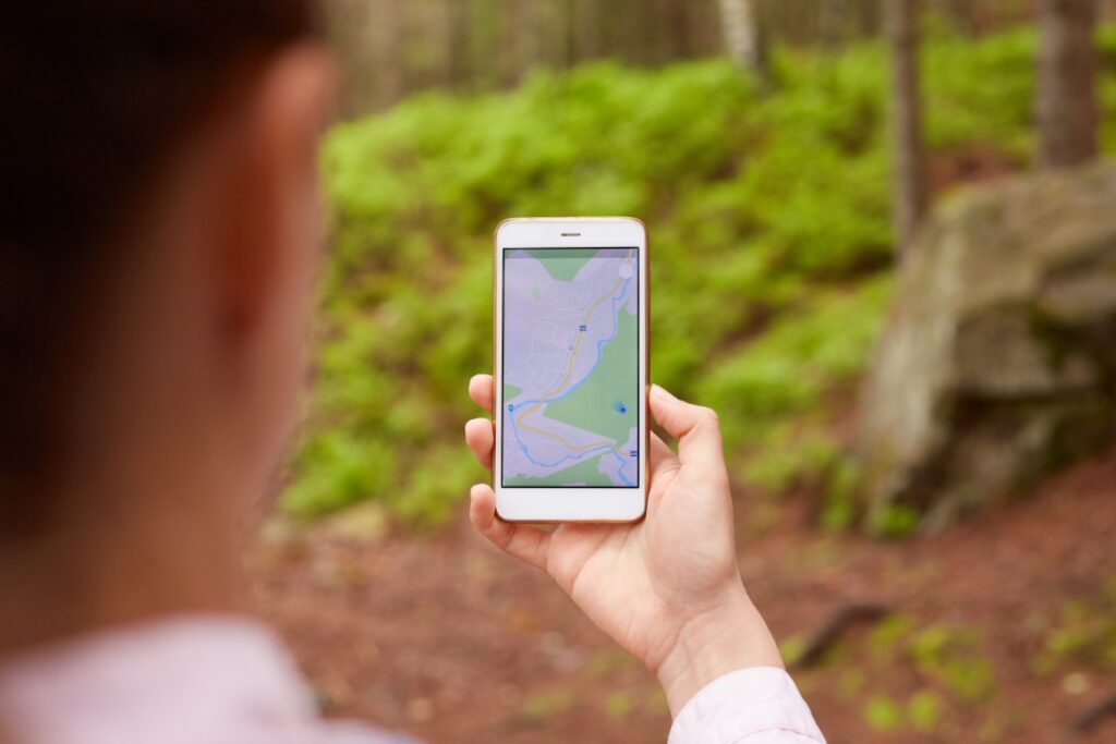 Kvinde bruger mobilnavigation til geocaching